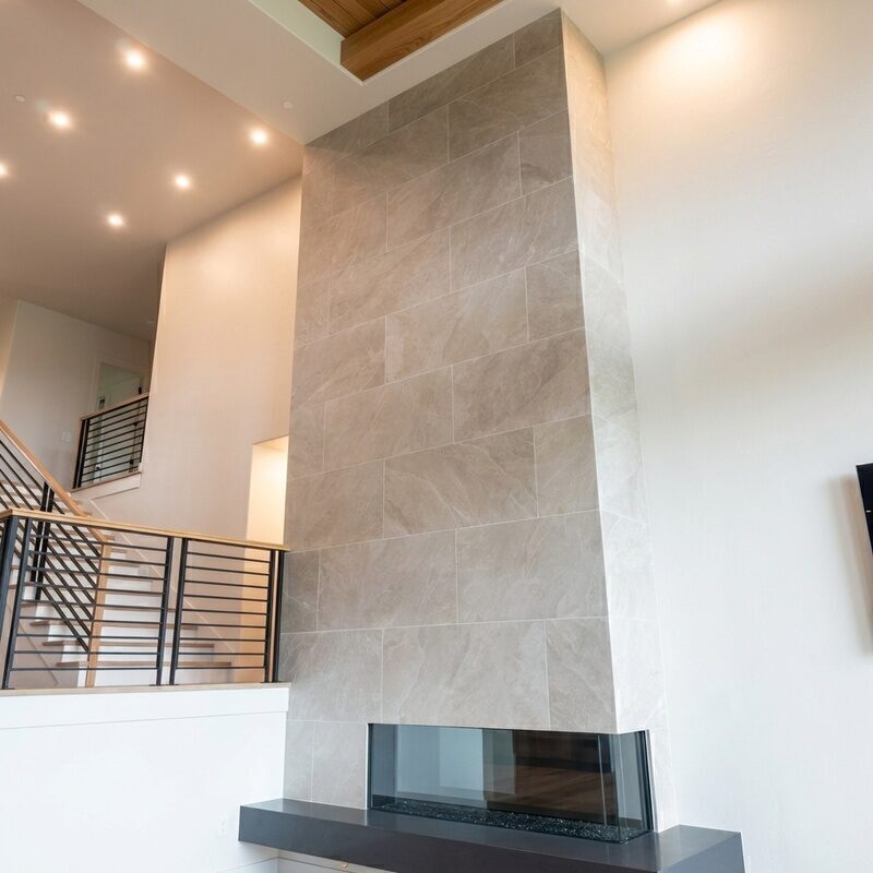Floor-to-ceiling large format porcelain tile fireplace surround in modern living room, installed by BM Pro Construction
