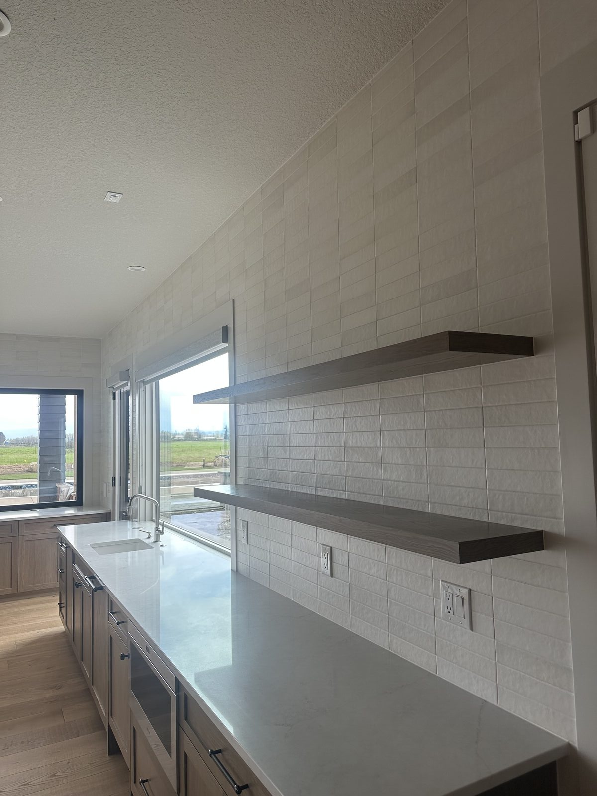 Large format porcelain tile floor installed in kitchen with tight grout joints