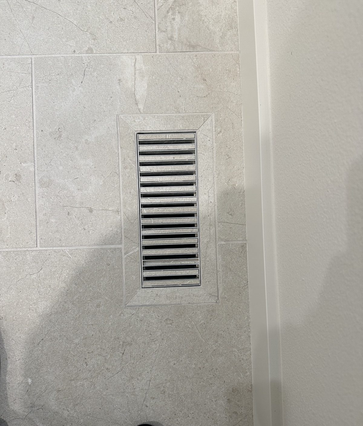Dark marble tile with illuminated recessed niche and polished stone detail