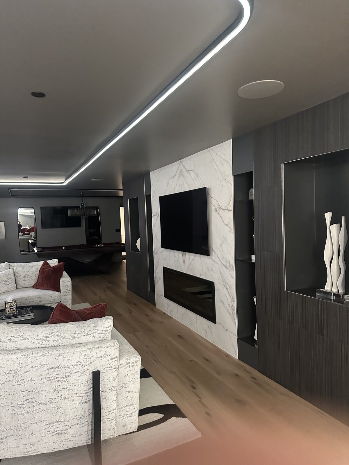 Living room with floor-to-ceiling marble tile feature wall and hardwood flooring transition