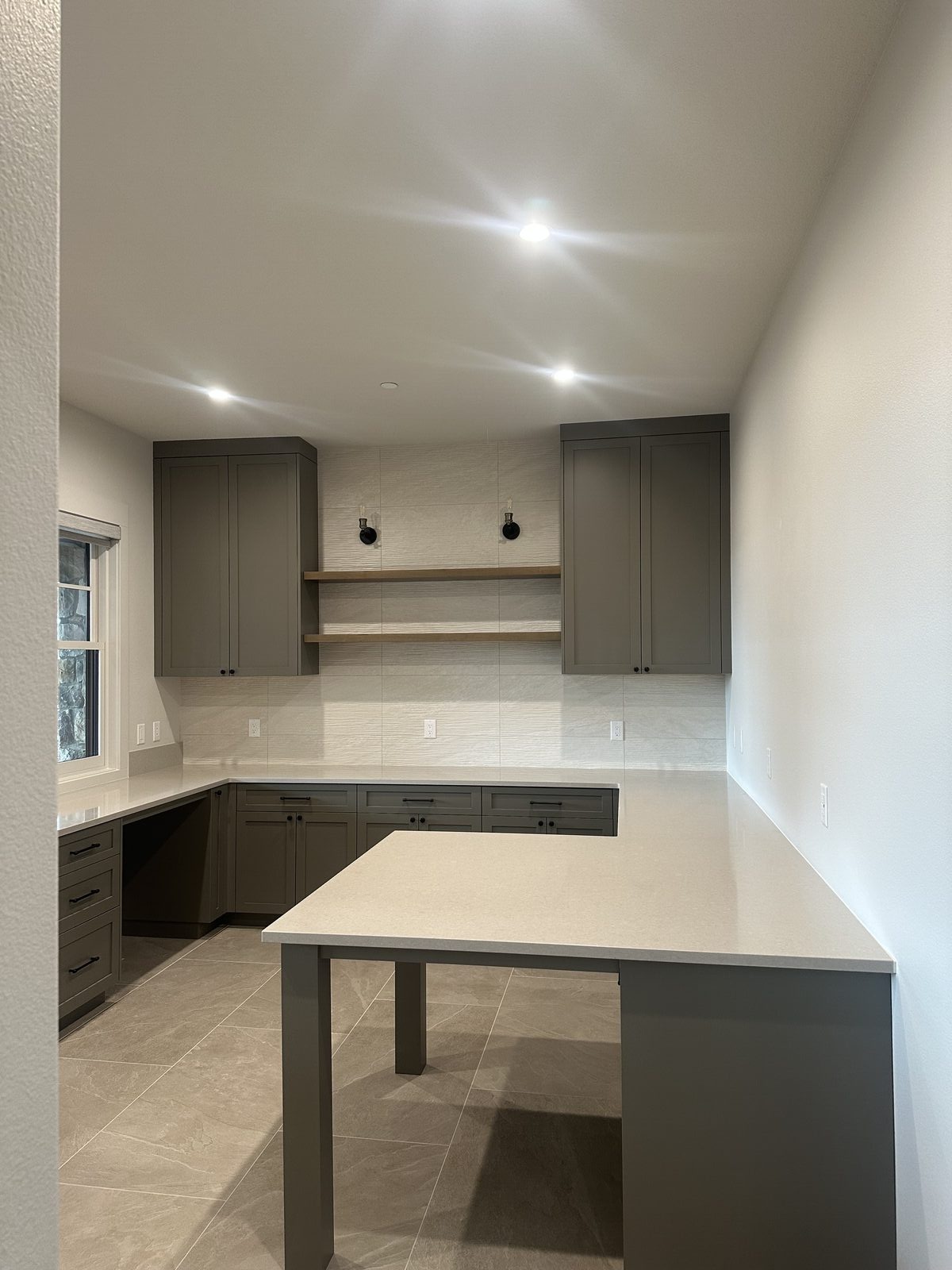 Sage green cabinetry with complementary tile surround installation