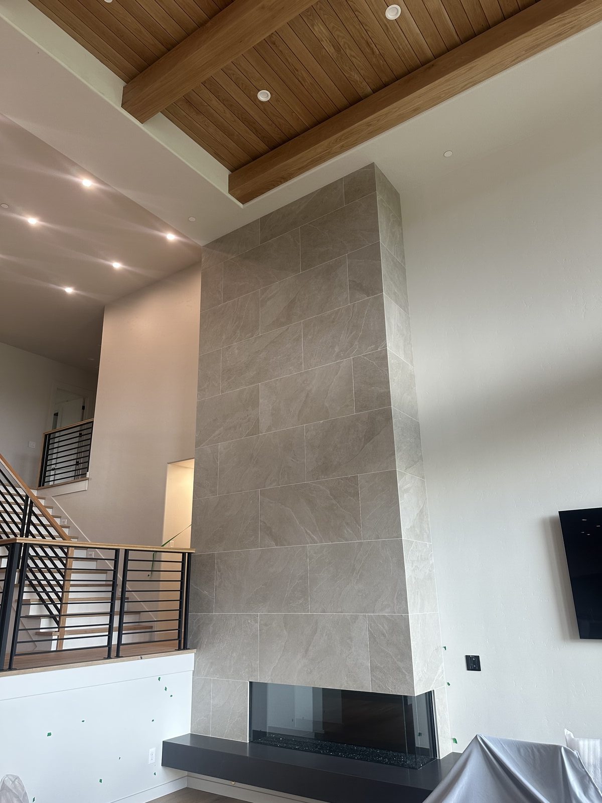 Floor-to-ceiling tile fireplace surround in modern living room, installed by BM Pro Construction